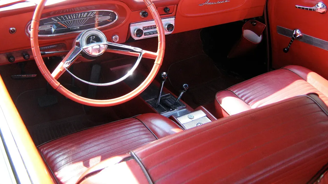Red front seats and dashboard inside a classic car