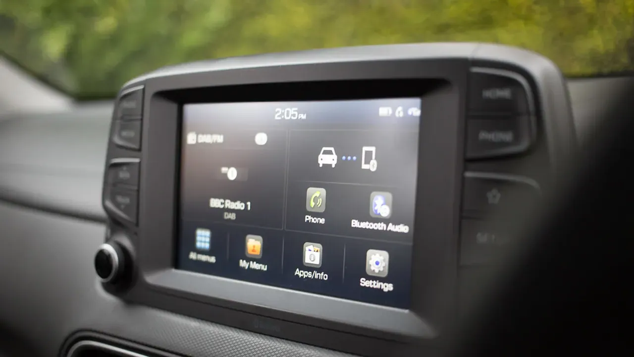 A modern car infotainment screen above dashboard controls