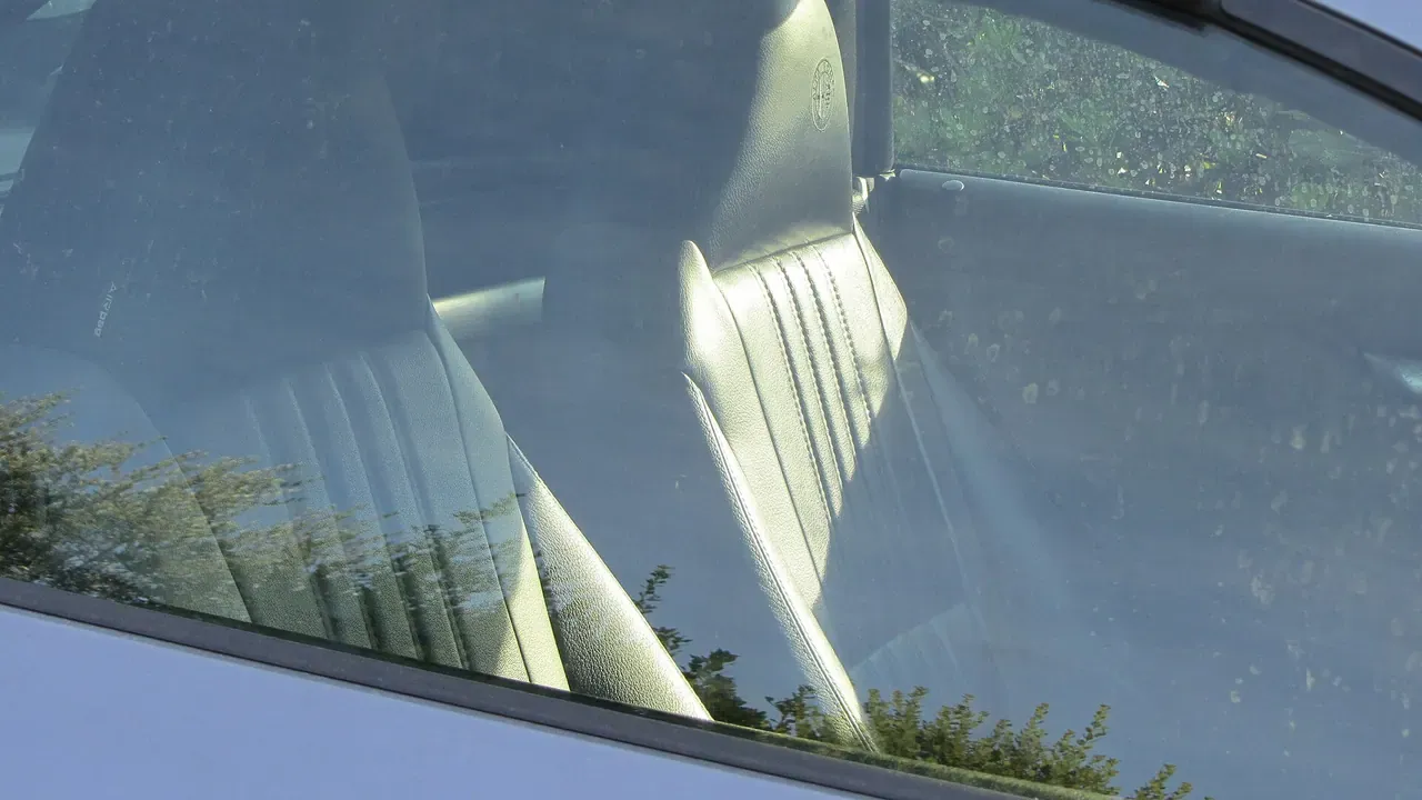 Dark front seats viewed through a car windshield