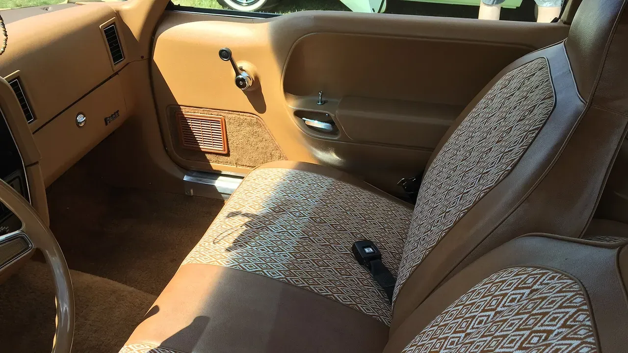 Tan fabric seats inside a two-door car