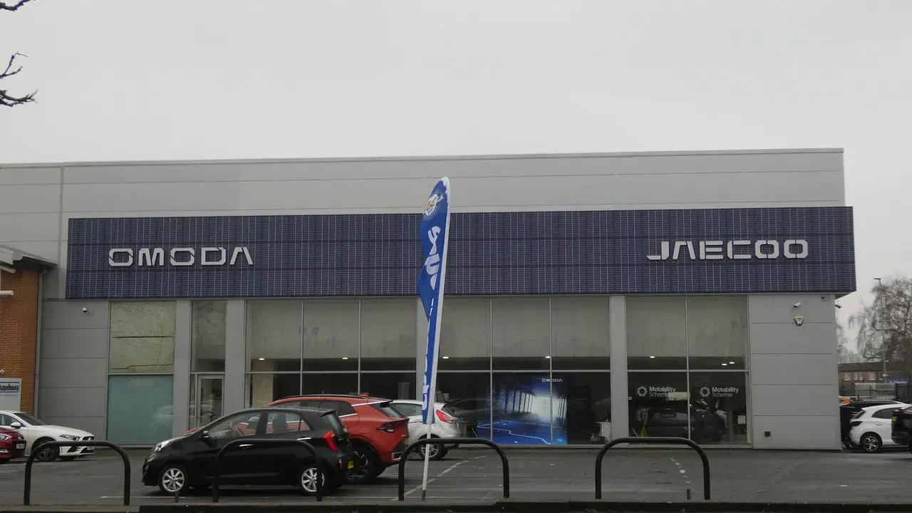 A modern car dealership exterior with vehicles parked outside