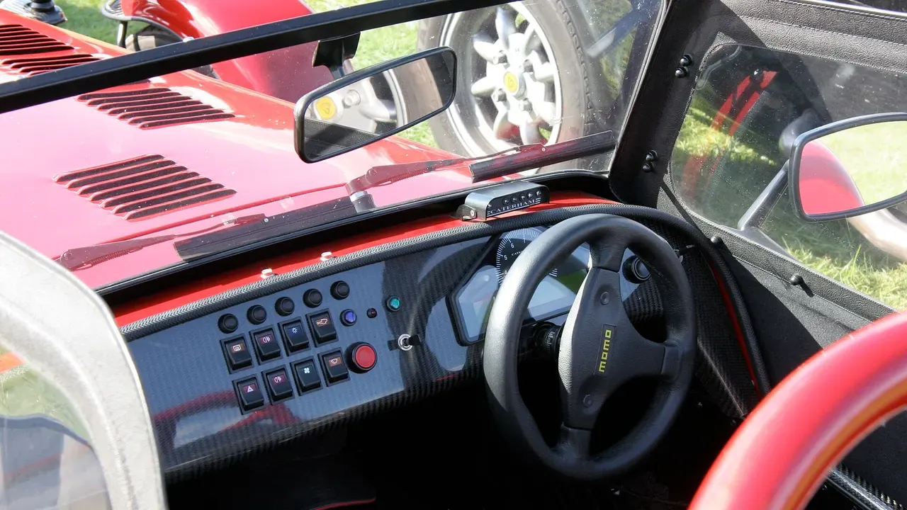 The dashboard and controls of a red open-top sports car