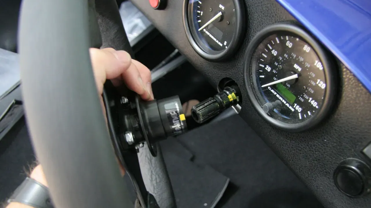 A hand aligning a removable steering wheel with its column