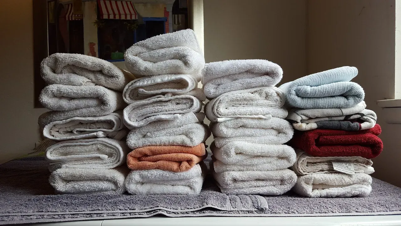 Stacks of clean folded towels organized by color and size