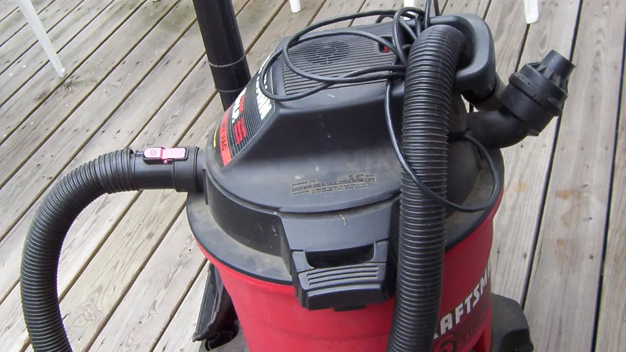 A wheeled wet-dry vacuum with its hose and power cord