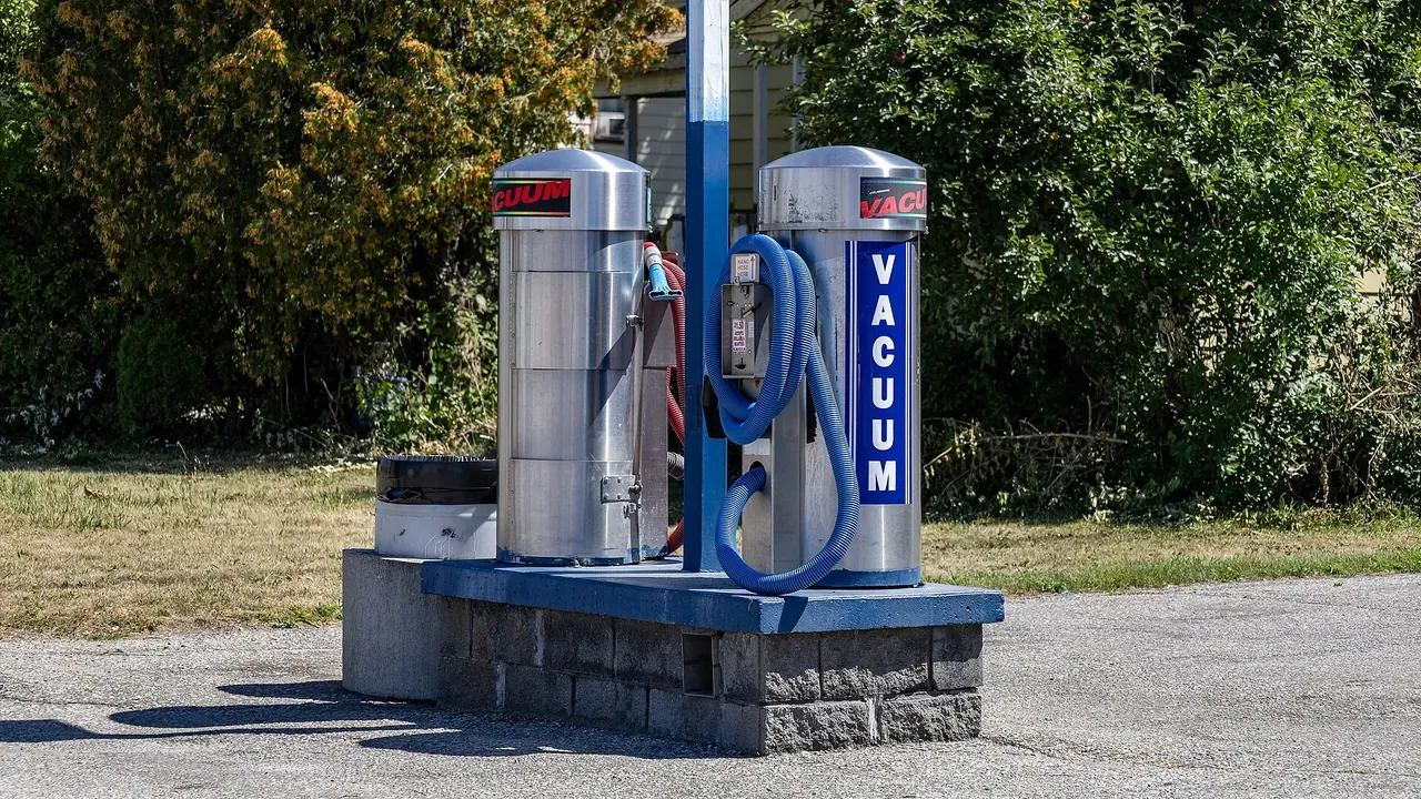 A self-service automobile vacuum beside a parking area